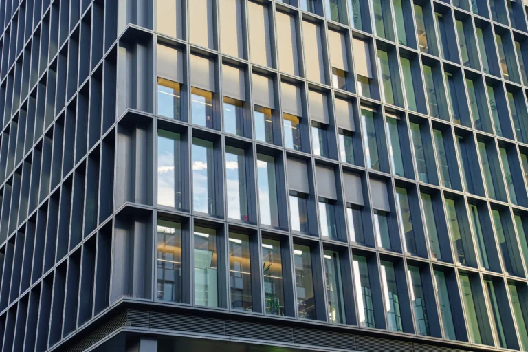 Close view of a modern building facade with rows of glass windows